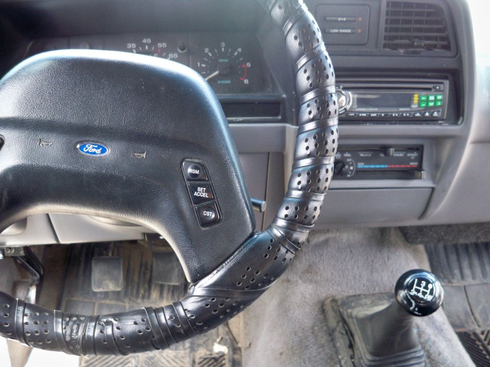 Interior of a 1994 Ford Explorer showing the steering wheel and manual gear shifter