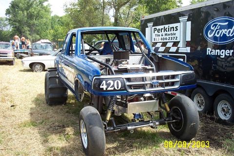 1996 Ford Bronco - Modified Ford Ranger pickup truck with large rear tires and number 420 on the grille. A Ford Ranger trailer is behind it.
