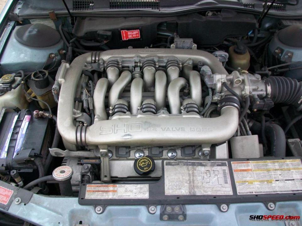 Engine bay shot of a 1993 Ford Taurus SHO, showing the V6 engine with "SHO 3.0L 24 VALVE DOHC" text on the intake manifold
