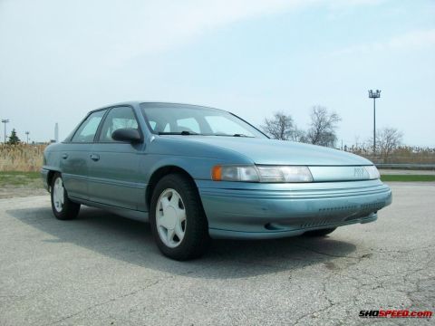 1993 Ford Taurus - This teal sedan is captured from a 3/4 front angle, showing its distinctive body style.