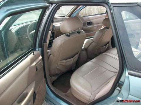 1993 Ford Taurus - The interior of a light blue 1993 Ford Taurus shows tan leather seats and dashboard details.