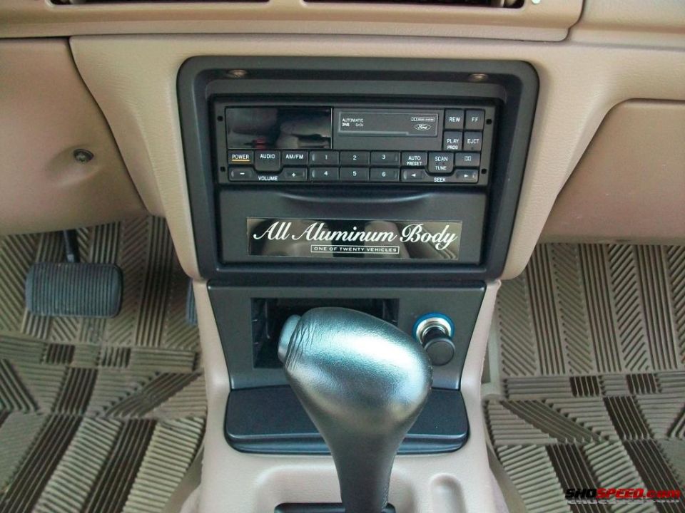 Car interior center console with automatic shifter, radio, and 'All Aluminum Body' sticker
