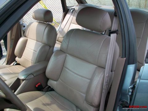 1993 Ford Taurus - The interior of a car shows tan leather seats and headrests, with seatbelts visible.