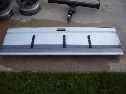 1996 Ford F-150 - A truck tailgate is shown on the ground with other vehicle parts nearby.
