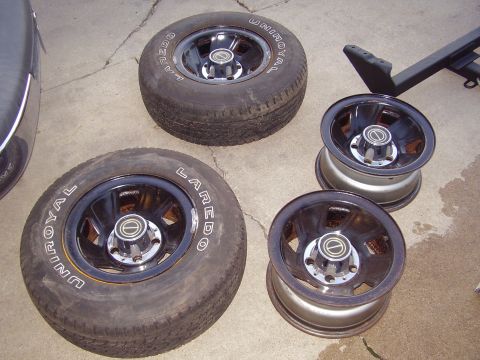 1996 Ford F-150 - A set of four wheels and tires, two mounted and two unmounted, are displayed on a concrete surface.