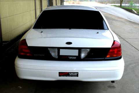 1998 Ford Crown Victoria - This sedan has a distinctive black panel and taillight design, suggesting a model year around 2000.