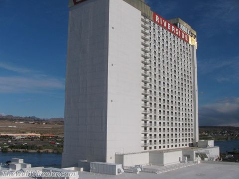 1996 Ford C-350 (Centurion Conversions) - A tall white hotel building with many balconies is seen under a bright blue sky.