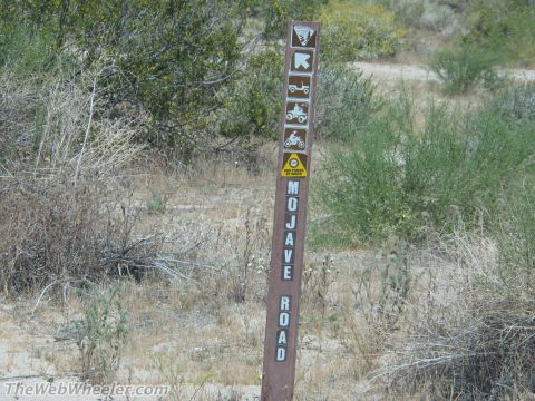 1996 Ford C-350 (Centurion Conversions) - Signpost indicates trails for various recreational vehicles and hiking in the Mojave Desert.