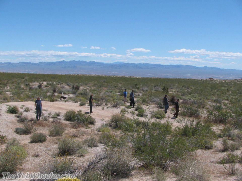Desert landscape with several people walking on a dirt path