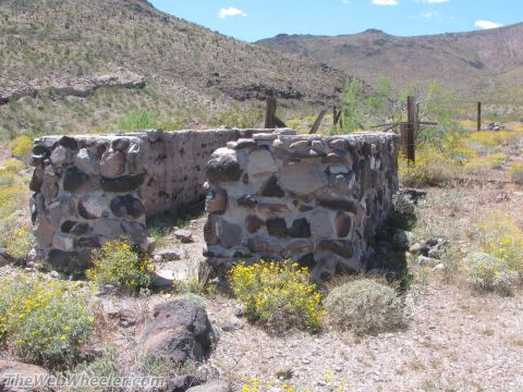 1996 Ford C-350 (Centurion Conversions) - Abandoned stone structure sits in a desolate desert landscape under a clear sky.