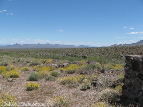 1996 Ford C-350 (Centurion Conversions) - A wide view of a desert scene with scattered rocks and vegetation, a stone structure on the right.