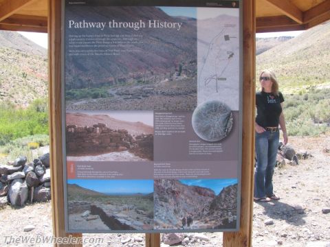 1996 Ford C-350 (Centurion Conversions) - A woman stands next to a large outdoor display detailing the history of the Mojave trail.