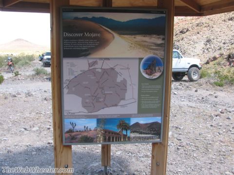 1996 Ford C-350 (Centurion Conversions) - A white Ford F-series truck is parked on a dirt road near a Mojave Discover sign.