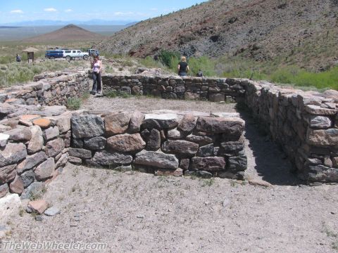 1996 Ford C-350 (Centurion Conversions) - Stone ruins stand in a desert landscape with two SUVs and people visible in the distance.