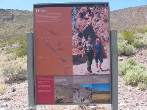1996 Ford C-350 (Centurion Conversions) - Signpost details hiking trails and safety precautions in a dry, mountainous environment.