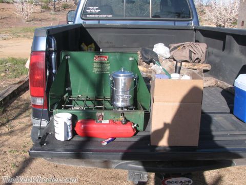 1996 Ford C-350 (Centurion Conversions) - Camping gear is packed in the bed of a pickup truck, ready for an outdoor adventure.