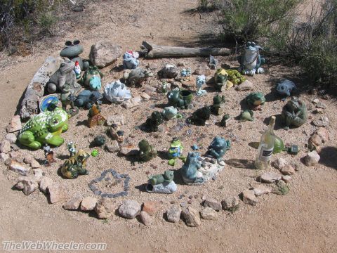 1996 Ford C-350 (Centurion Conversions) - A whimsical display of various frog statues and garden gnomes decorates a desert landscape.
