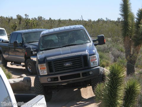 1996 Ford C-350 (Centurion Conversions) - A Ford Super Duty pickup truck is parked on a dirt path in a desert landscape.