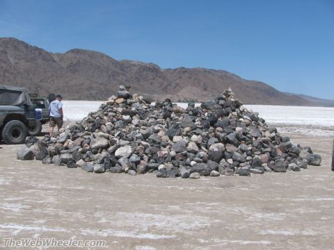1996 Ford C-350 (Centurion Conversions) - Rock cairns mark a trail in a desert landscape, with off-road vehicles present.