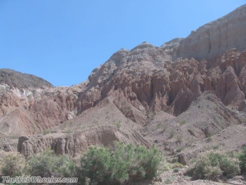 1996 Ford C-350 (Centurion Conversions) - Rocky desert landscape with eroded hills and a bright blue sky overhead.