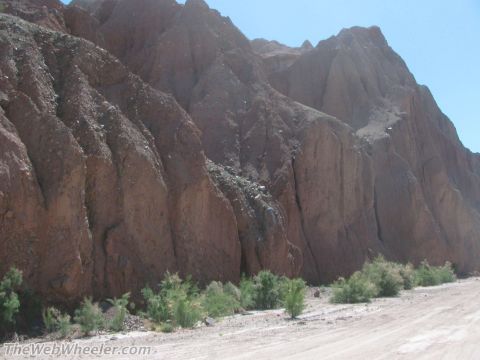1996 Ford C-350 (Centurion Conversions) - A dry, rocky landscape with layered mountains under a clear blue sky.