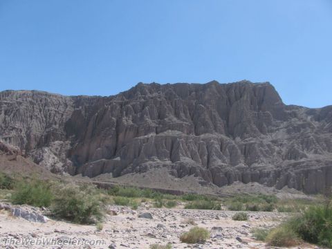 1996 Ford C-350 (Centurion Conversions) - Eroded mountains dominate a desert landscape with sparse vegetation and rocky ground.