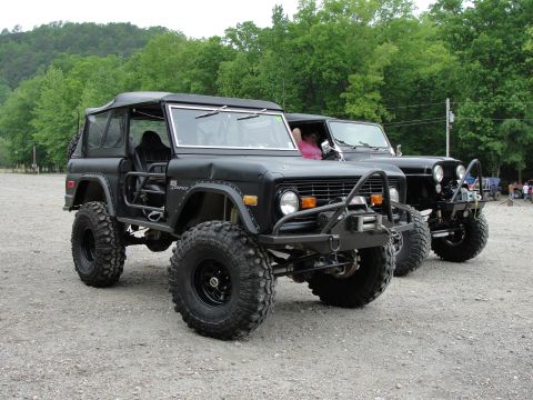 1967 Ford Mustang - Two modified off-road vehicles, a black Ford Bronco and a Jeep, are parked outdoors.