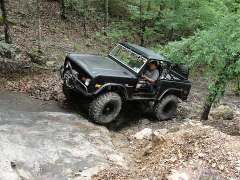 1967 Ford Mustang - A black Ford Bronco navigates a challenging rocky terrain on an off-road trail.