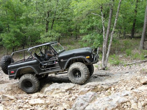1967 Ford Mustang - A black 1977 Ford Bronco navigates a rocky trail, its off-road capabilities.