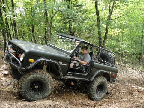 1967 Ford Mustang - This modified Ford Bronco is navigating a rocky, wooded trail with a driver behind the wheel.