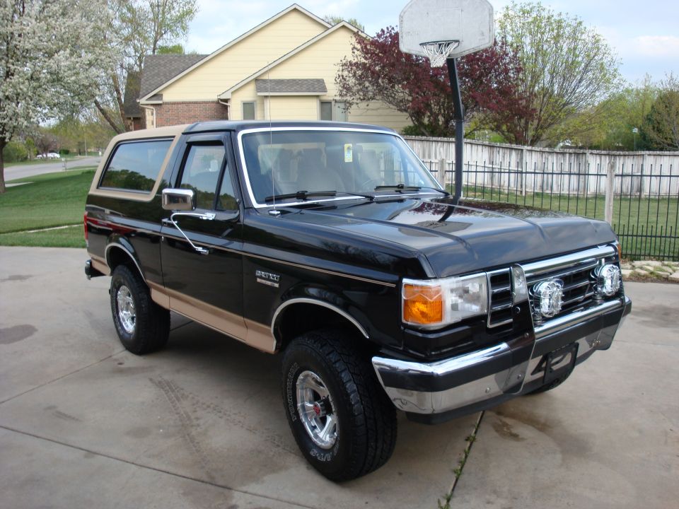 Black 1989 Ford Bronco with tan trim parked in driveway