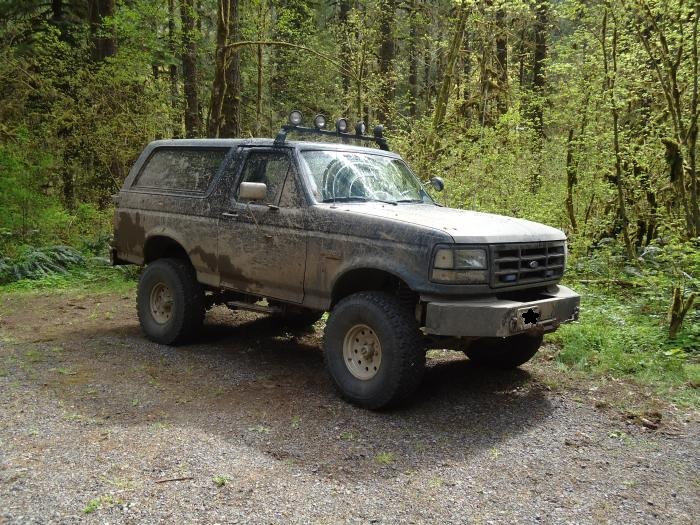 1995 Ford Bronco 3q-front view, covered in mud, with roof lights