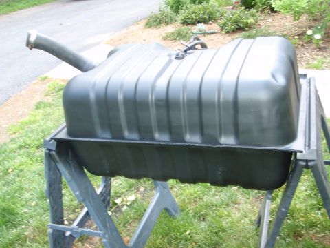 1995 Ford Bronco - A dark green gas tank with ribbed sides is shown resting on sawhorses outdoors.