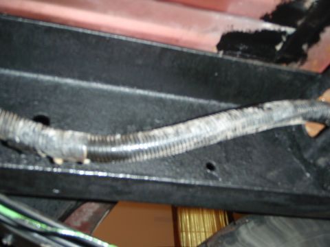 1995 Ford Bronco - Close-up view of a vehicle's undercarriage, showing a wire loom and frame components.