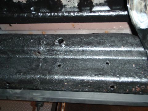 1995 Ford Bronco - Close-up view of the vehicle's undercarriage, showing frame details and some rust.