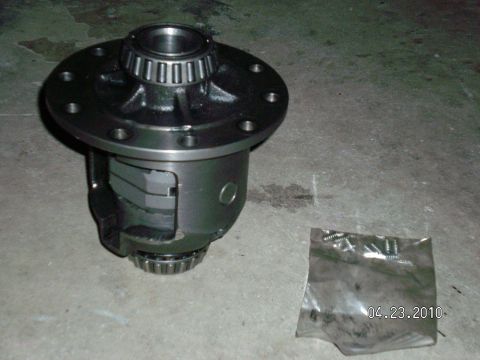1996 Ford Bronco - Differential carrier with bearings and a bag of screws on a concrete floor.