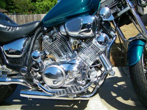 1992 Yamaha Virago - Close-up view of a teal motorcycle's engine and seat, chrome details and 'Virago' badging on the side.