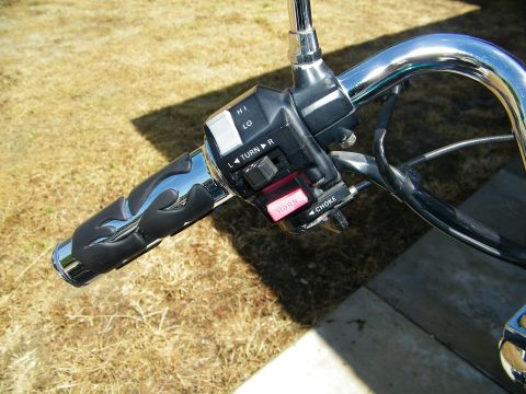 1992 Yamaha Virago - Close-up of motorcycle handlebar controls, including flame-patterned grips and various switches.