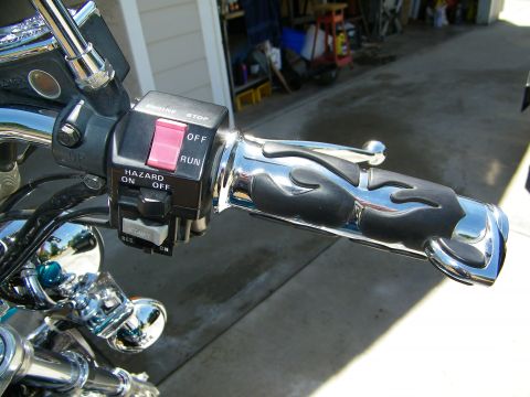 1992 Yamaha Virago - Close-up of motorcycle handlebar controls, including switches and grips with flame design.
