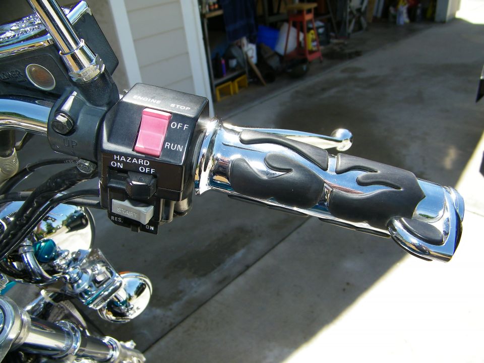 Motorcycle handlebar with engine stop/run switch, hazard lights, and flame-patterned grips