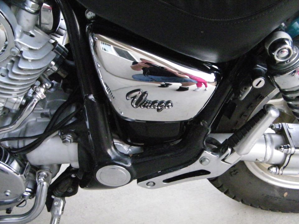 Close-up of motorcycle engine and chrome side panel with 'Virago' script