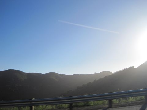 1989 Toyota Pickup/SR5 - A bright sun shines over rolling hills, with a guardrail in the foreground.