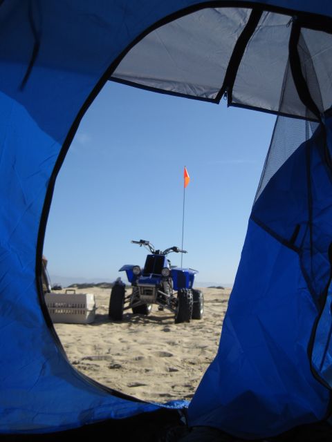 1989 Toyota Pickup/SR5 - View from inside a tent shows a blue ATV parked on a sandy beach under a clear blue sky.
