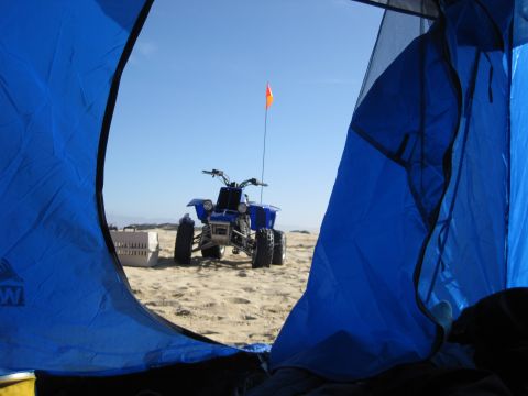 1989 Toyota Pickup/SR5 - View of a blue ATV on the sand through the opening of a blue tent.