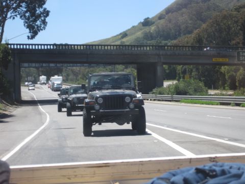 1989 Toyota Pickup/SR5 - Multiple Jeep Wranglers are seen on the highway, traveling under a concrete overpass on a sunny day.