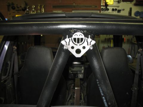 1985 Ford Bronco - A decorative plate with a smiley face is attached to the interior roll cage of a vehicle.