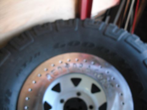 1991 Ford Bronco - A close-up view of a tire and wheel assembly, a beadlock rim with visible text.