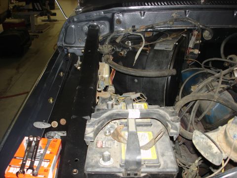 1979 Ford F-250 - The engine bay of a vehicle, a battery, hoses, and various electrical components.