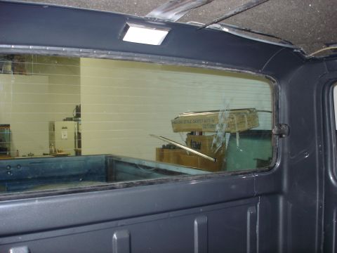 1979 Ford F-250 - Looking through the rear window of a truck cab at boxes in the bed. The window has horizontal defroster lines.