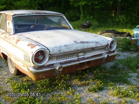 1963 Ford Galaxie - This 1963 Ford Galaxie shows significant wear and tear, with rust visible on the bumper and faded paint.